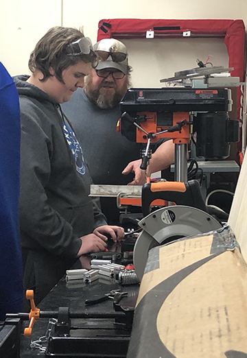 Father and son working with machinery.